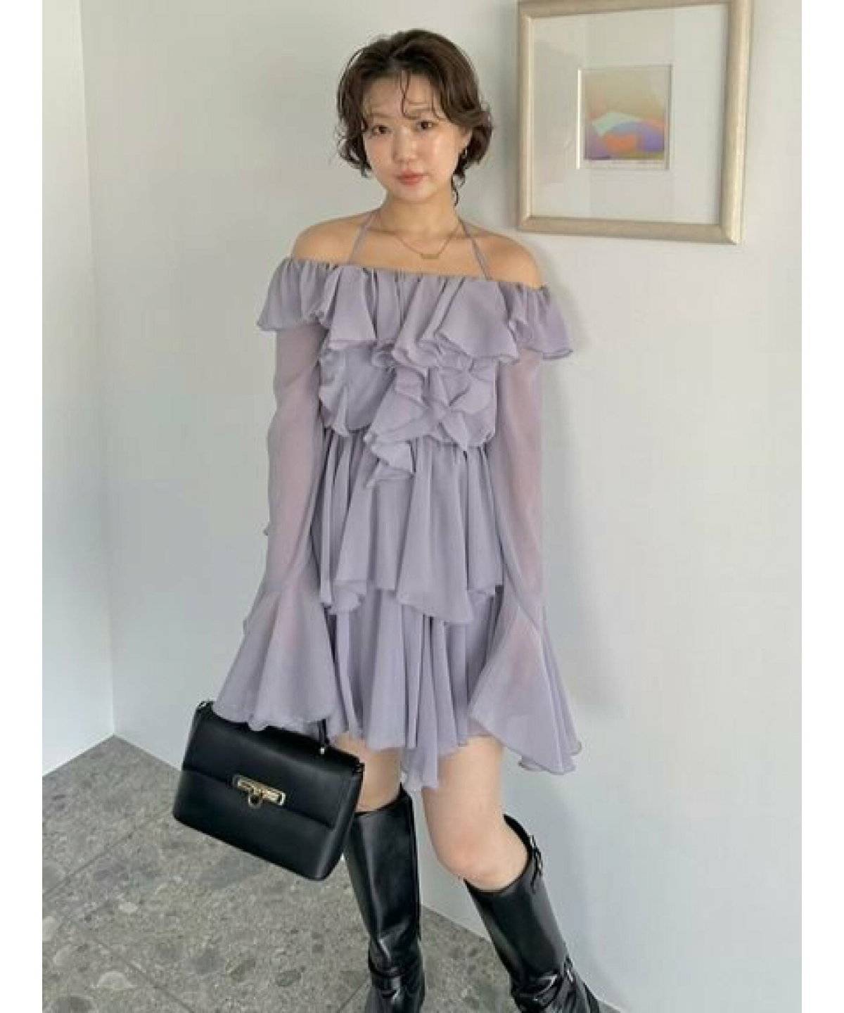 ラベンダーティアードワンピース✕黒のバッグ＆ブーツの女性