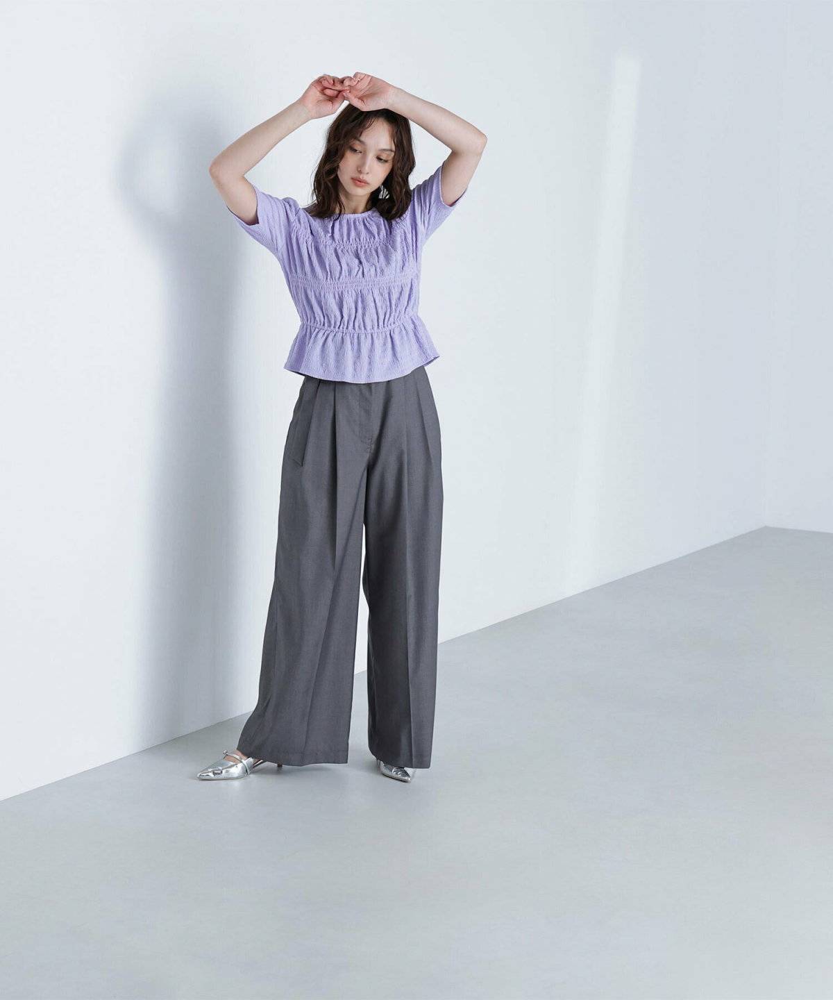 ラベンダーシャツ✕グレーのパンツの女性