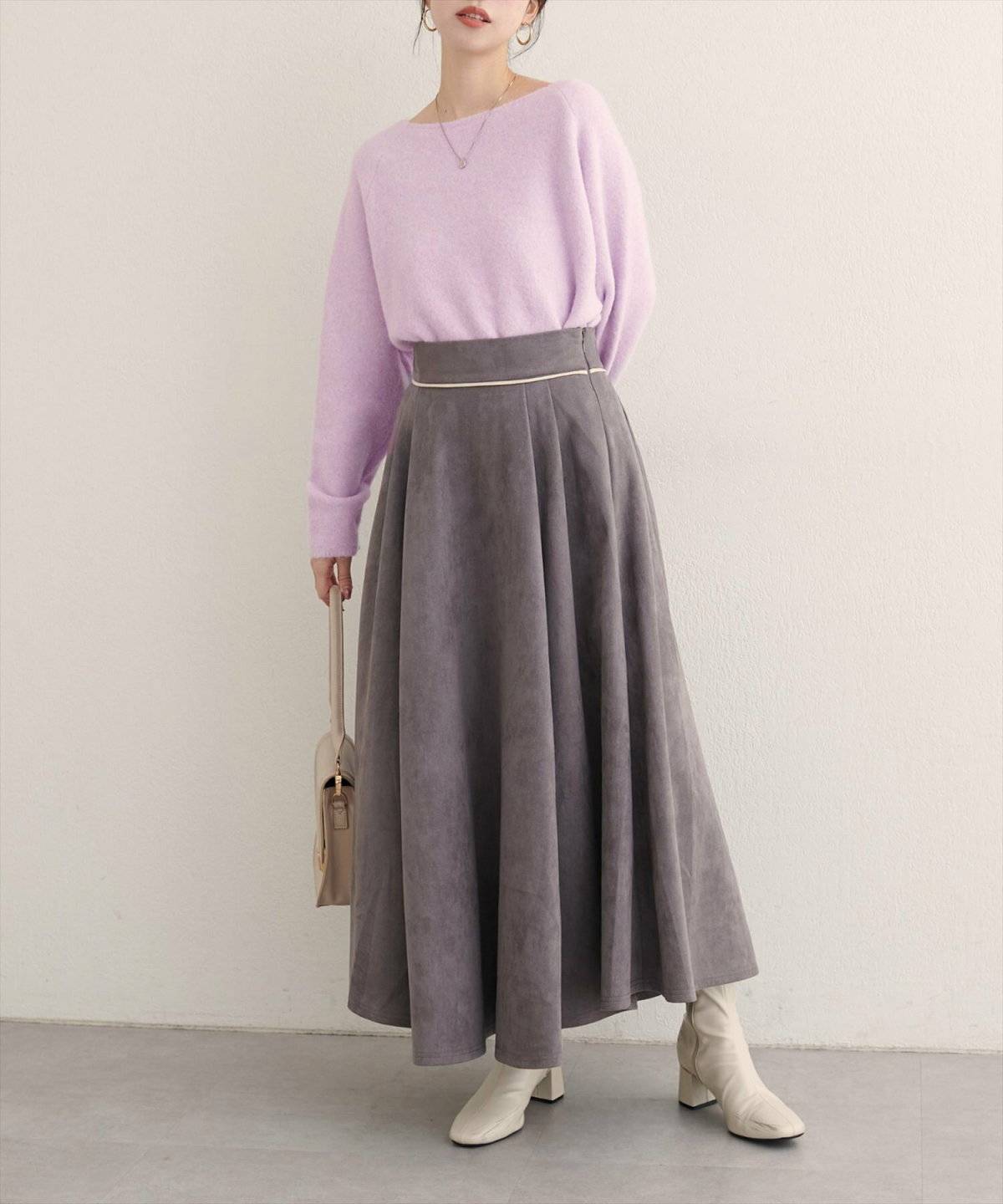 ラベンダーニット✕グレーのフレアスカートの女性
