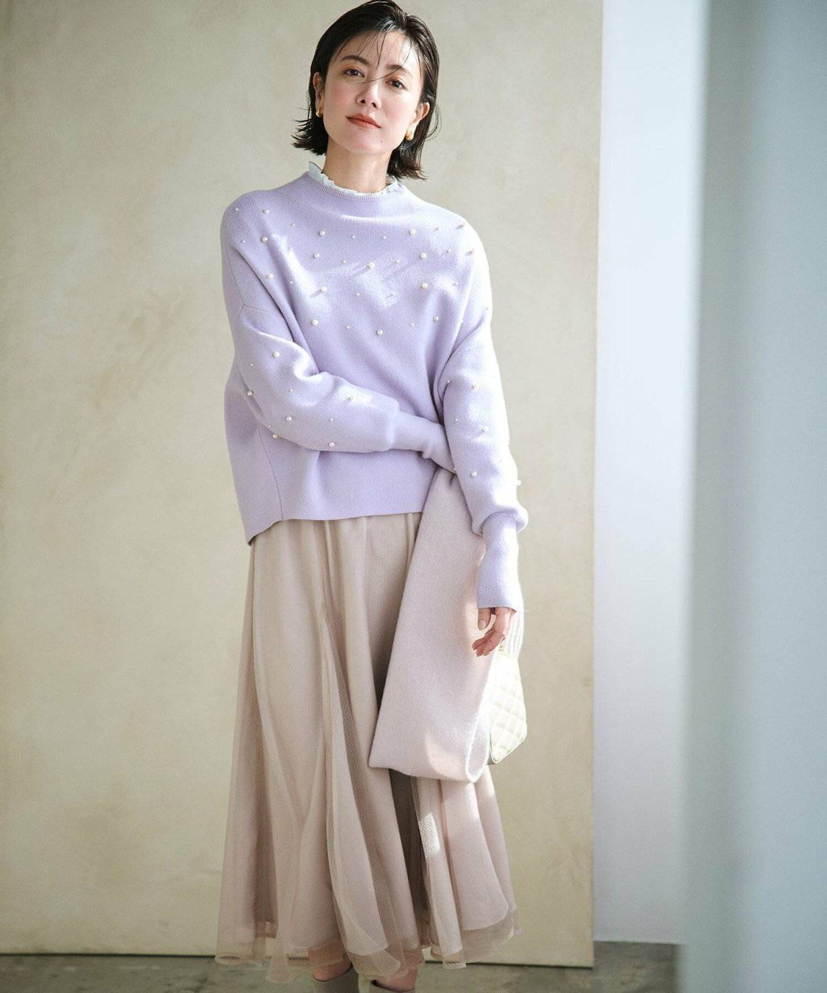 ラベンダーブラウス✕ベージュスカートの女性