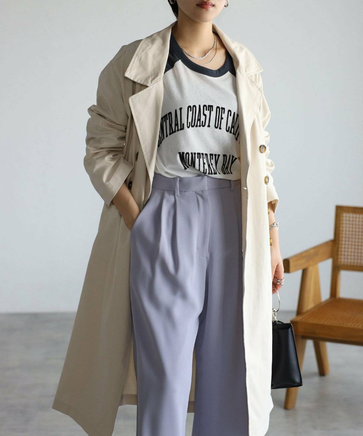 ラベンダーパンツ✕ベージュのトレンチコートの女性