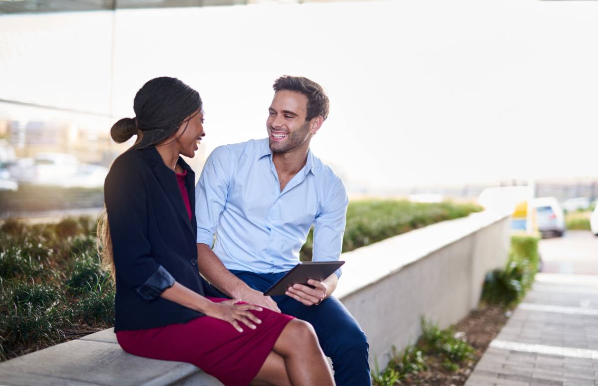 屋外で座りながら話し合う男女