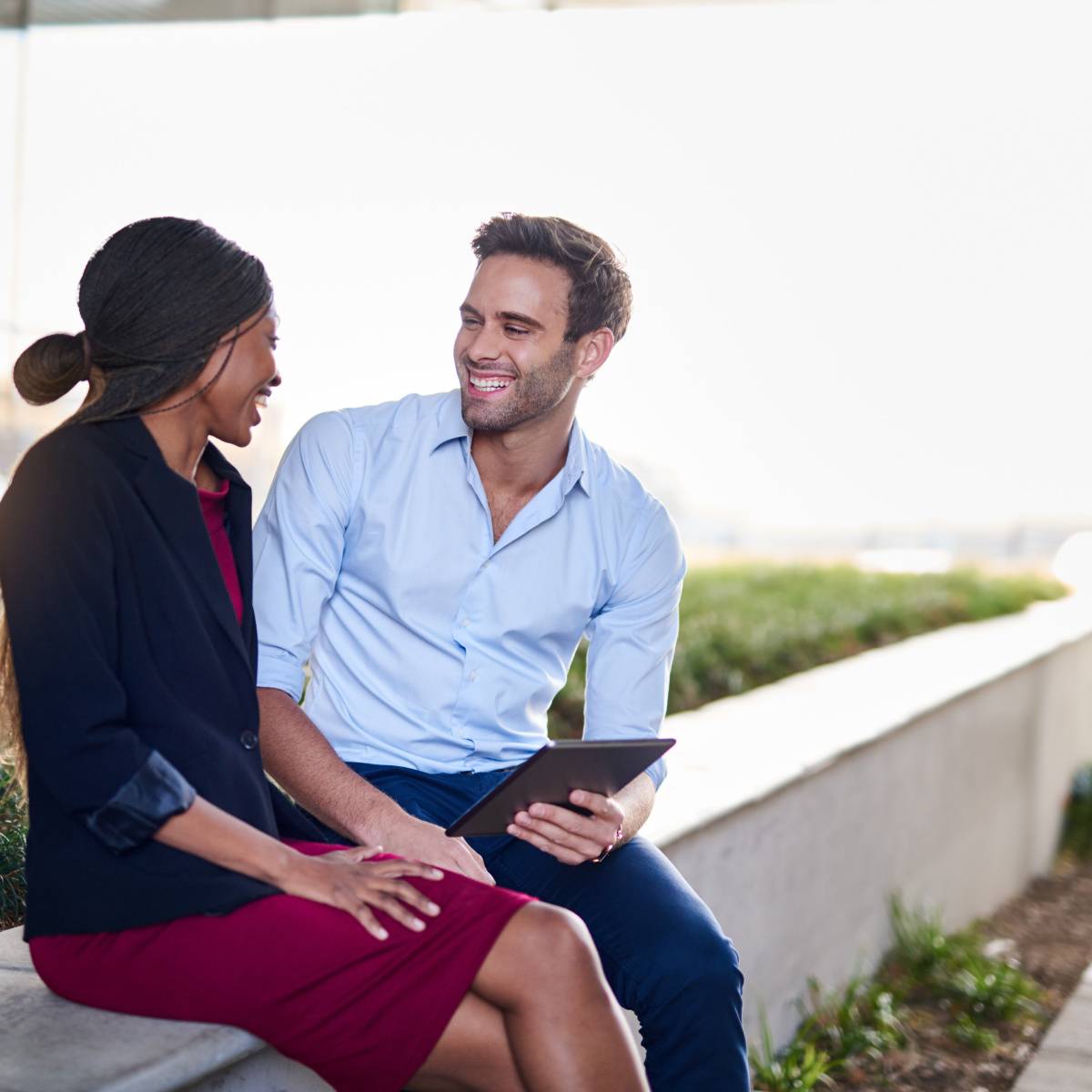 屋外で座りながら話し合う男女