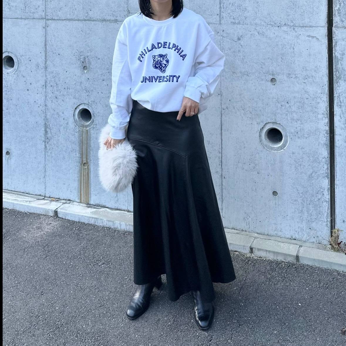 グレーのスウェットに黒スカートを合わせた女性