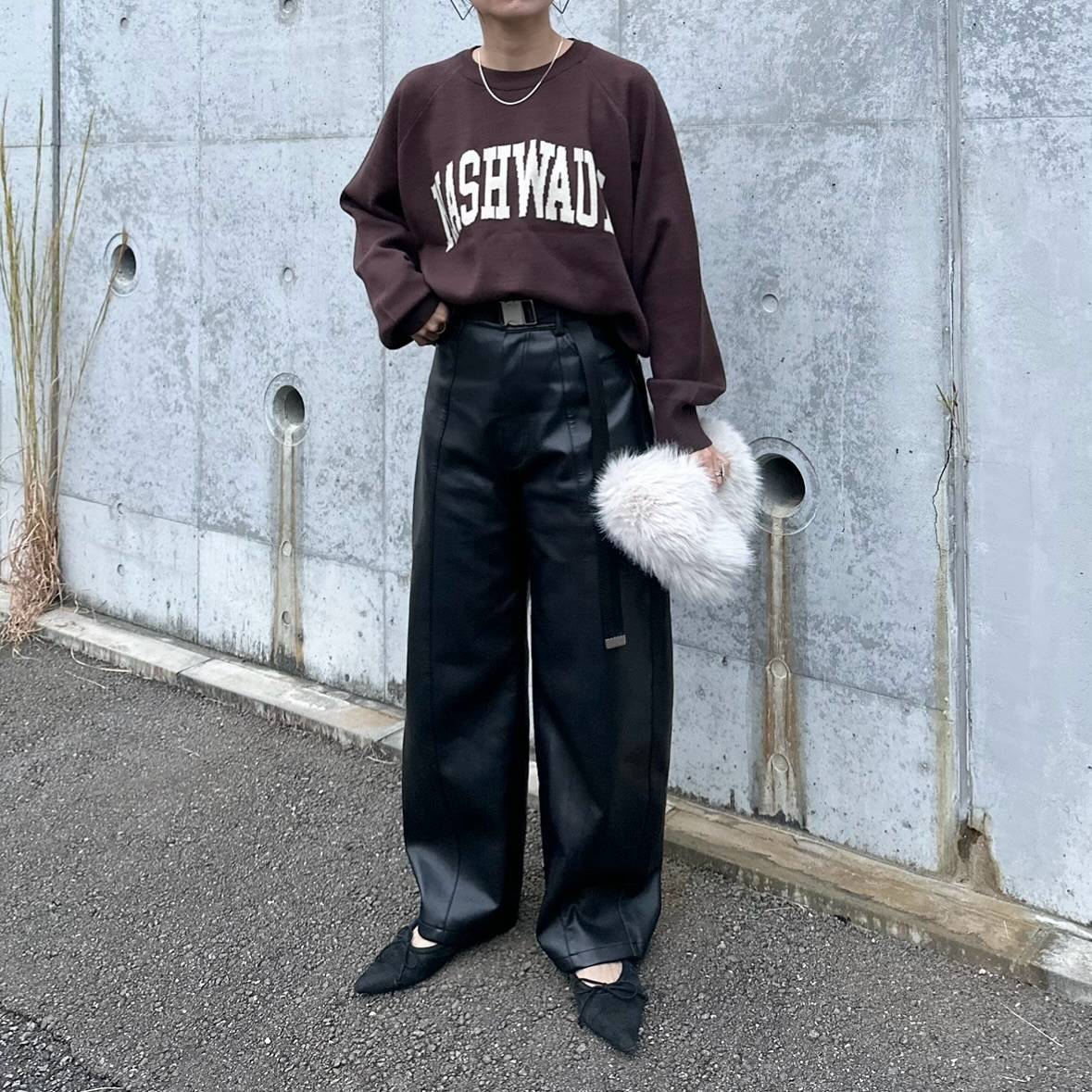 ブラウントップスに黒パンツを合わせた女性