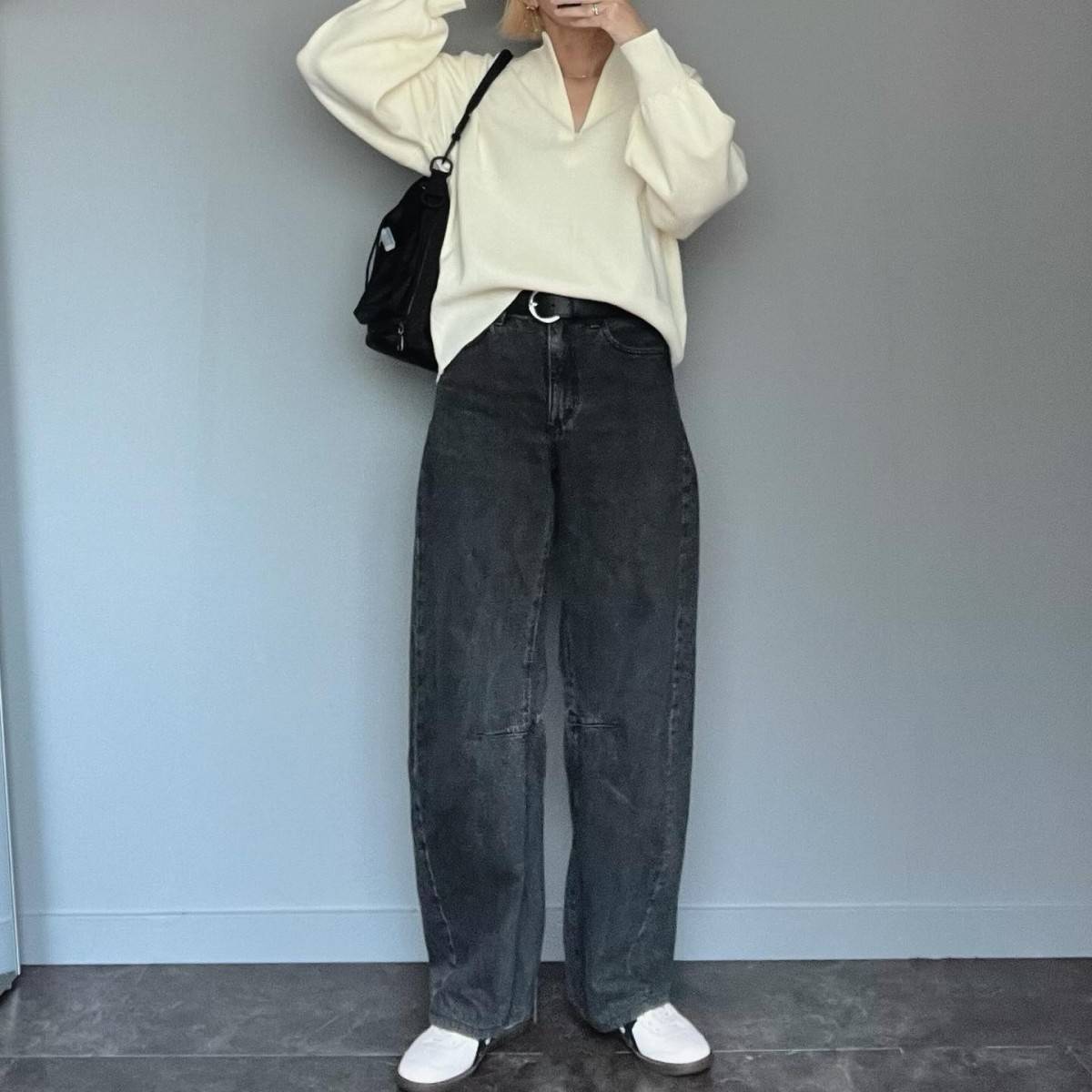 白ニットにデニムパンツを合わせた女性