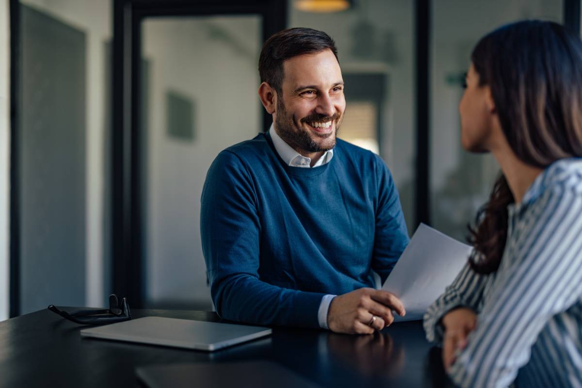 会議室で同僚の女性と話す男性