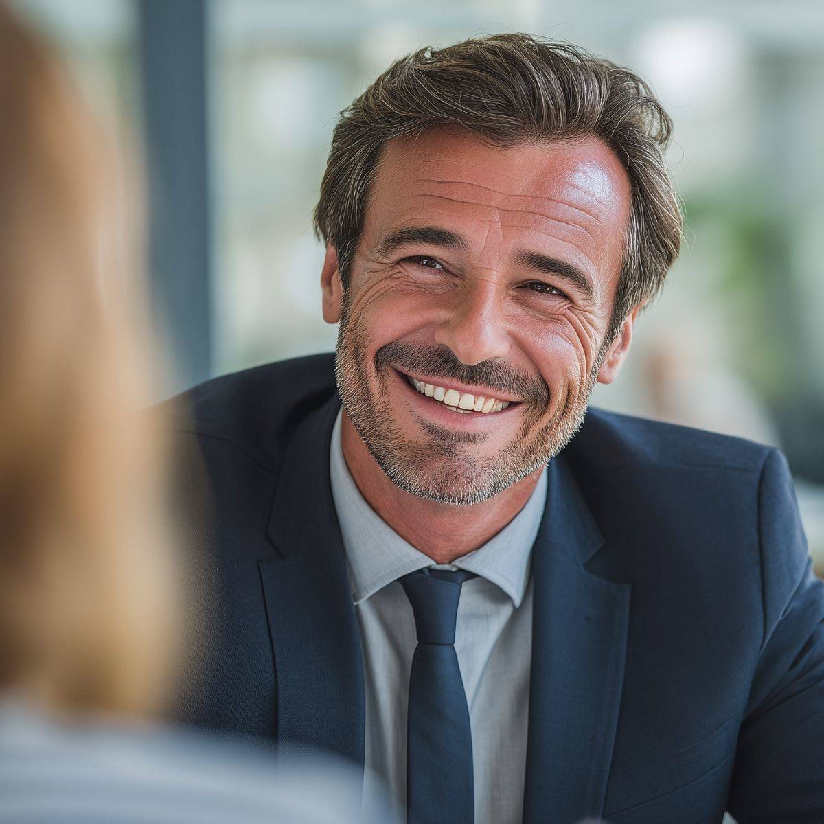 同僚の女性と話す笑顔の男性