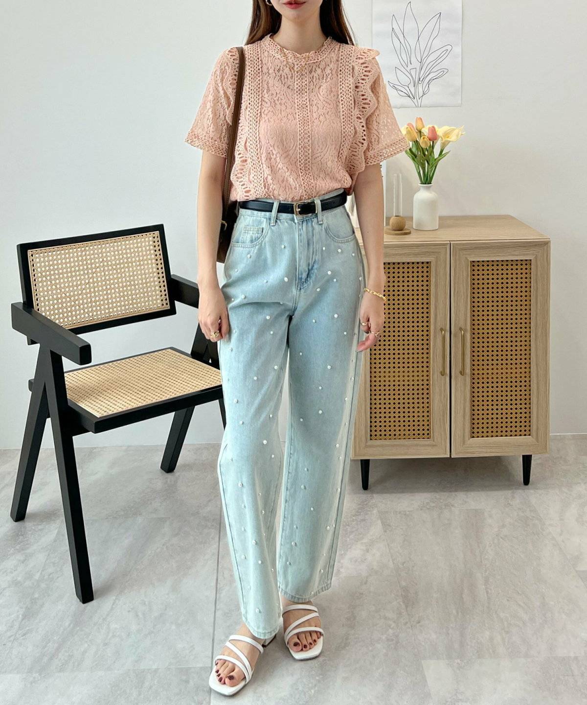 オレンジのブラウスにデニムを合わせた女性