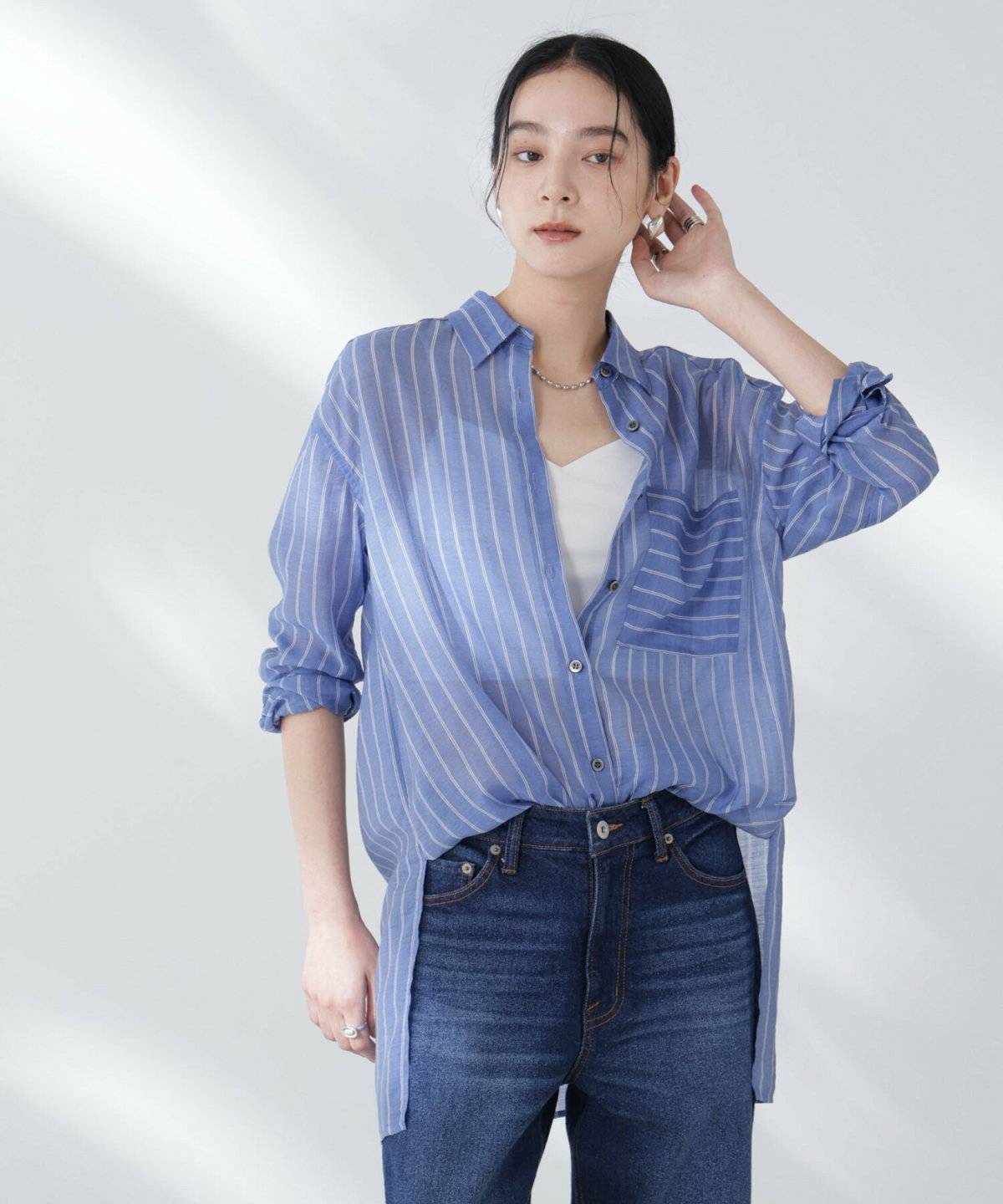 ストライプ柄のシャツにデニムを合わせた女性