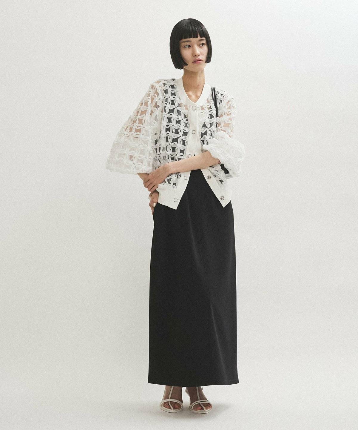 ワンピースに白のブラウスを羽織った女性