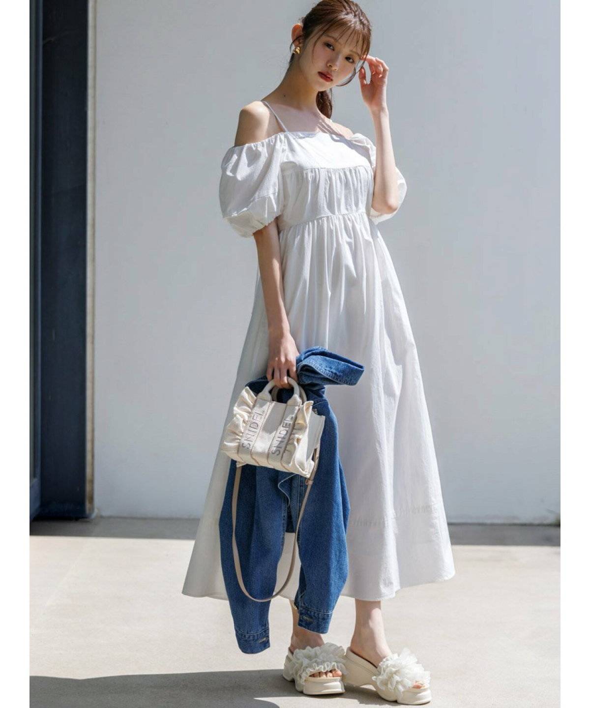 ワンピースにデニムを重ねた女性