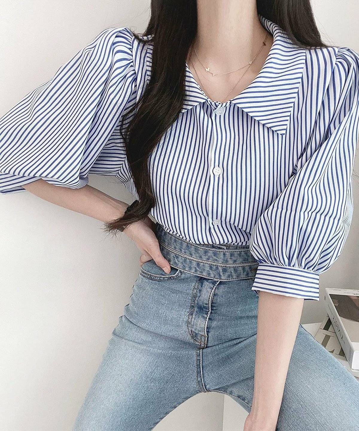 ストライプ柄のブラウスにデニムを合わせた女性