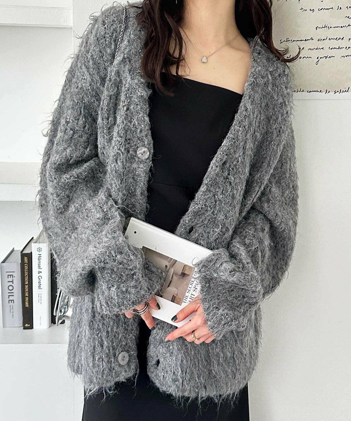 黒コーデにグレーカーディガンを羽織った女性