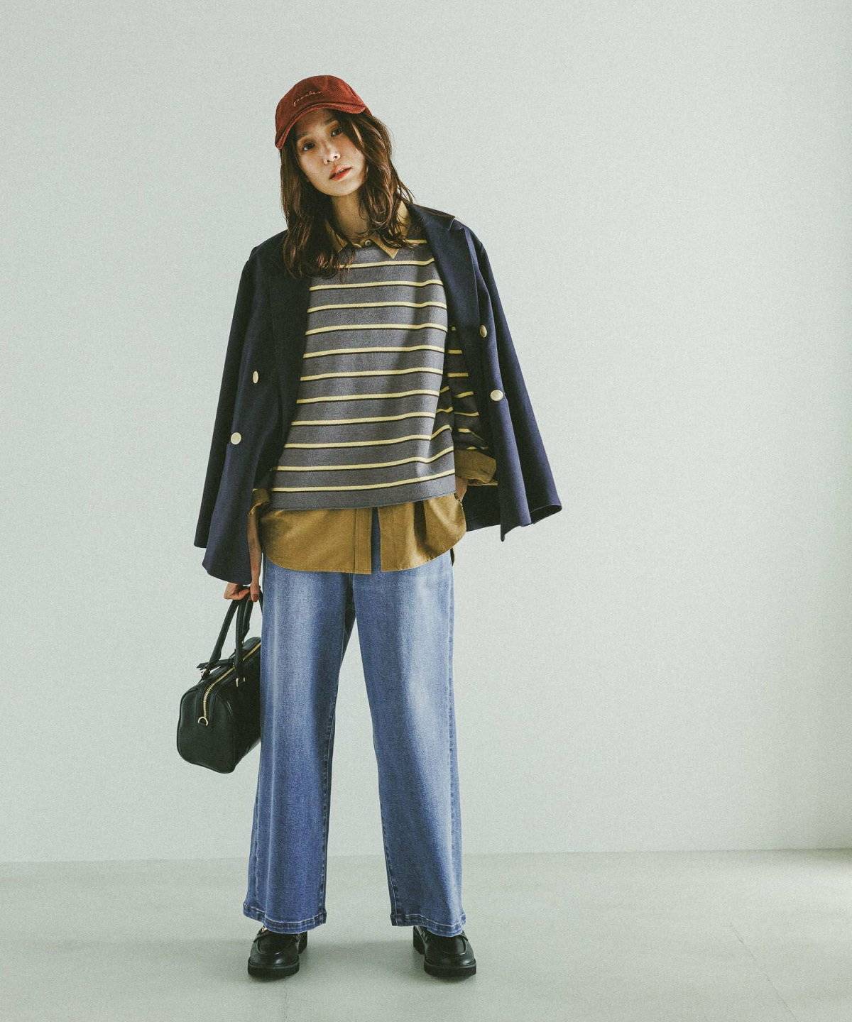 ボーダー柄トップスにデニムを合わせてジャケットを羽織った女性