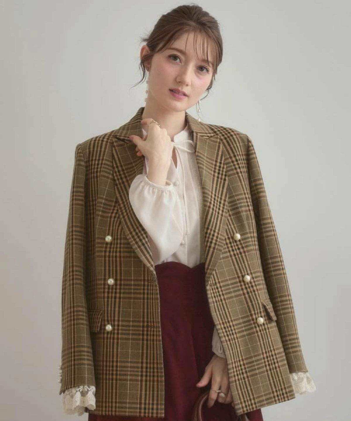 チェック柄ジャケットを肩掛けしてパンツを合わせた女性