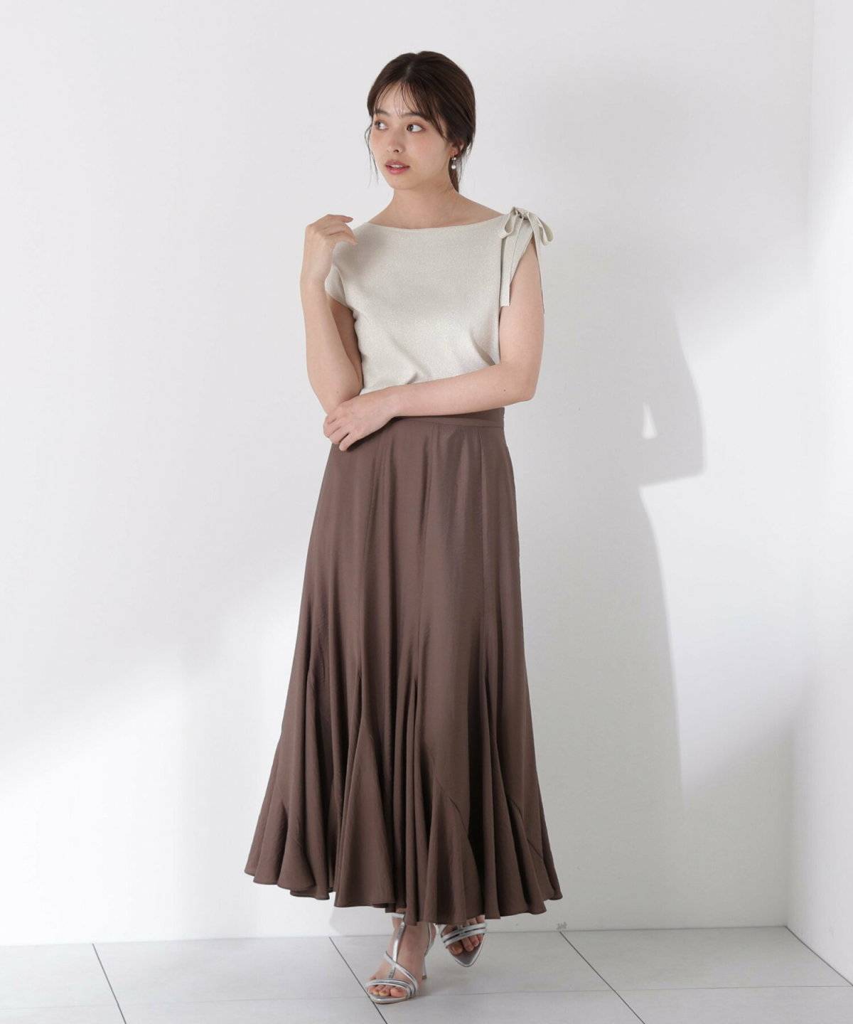 白トップスにブラウンのマーメイドスカートを合わせた女性