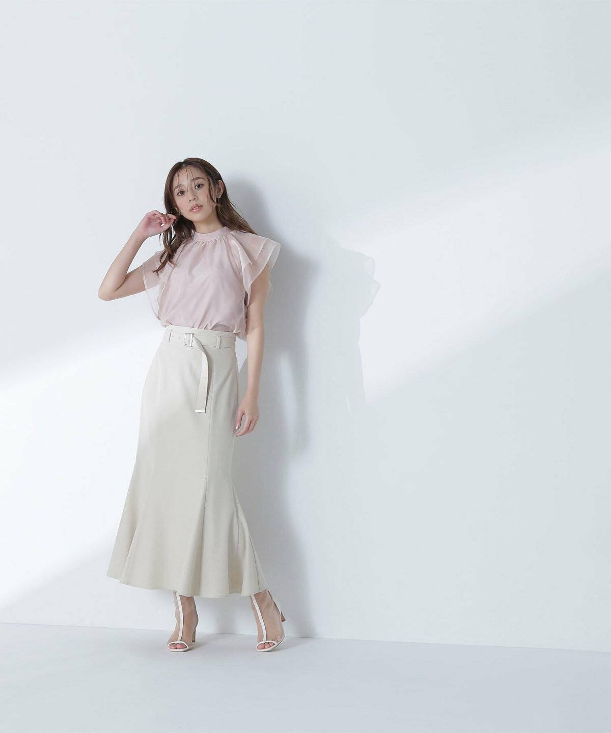 ブラウスにベージュのマーメイドスカートを合わせた女性