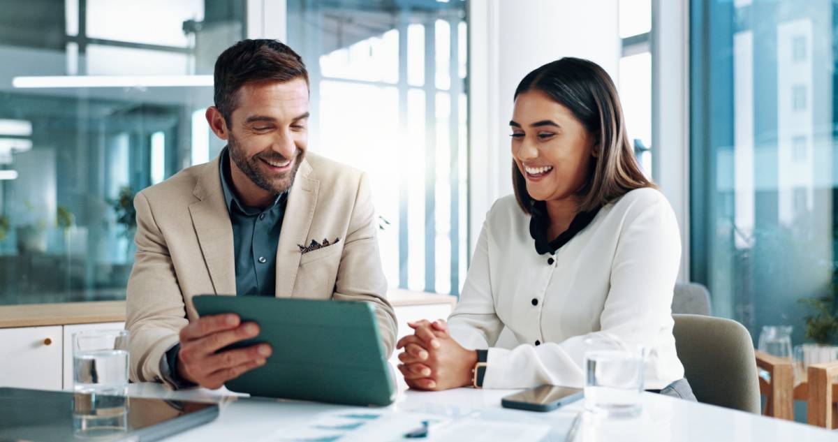 タブレットを見ながら話し合う男女