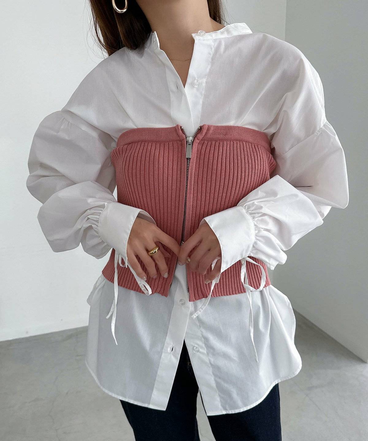 シャツにニットベストを重ねてパンツを合わせた女性