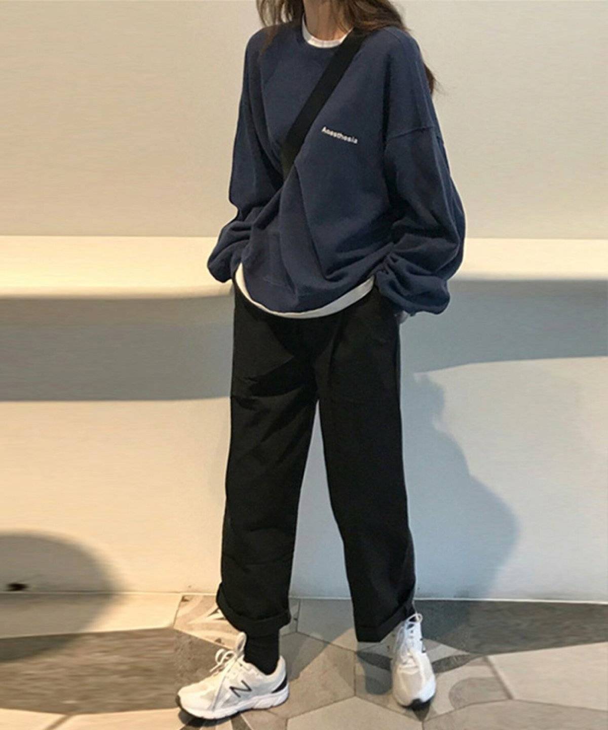 ネイビーのロングTシャツに黒スカートを合わせた女性