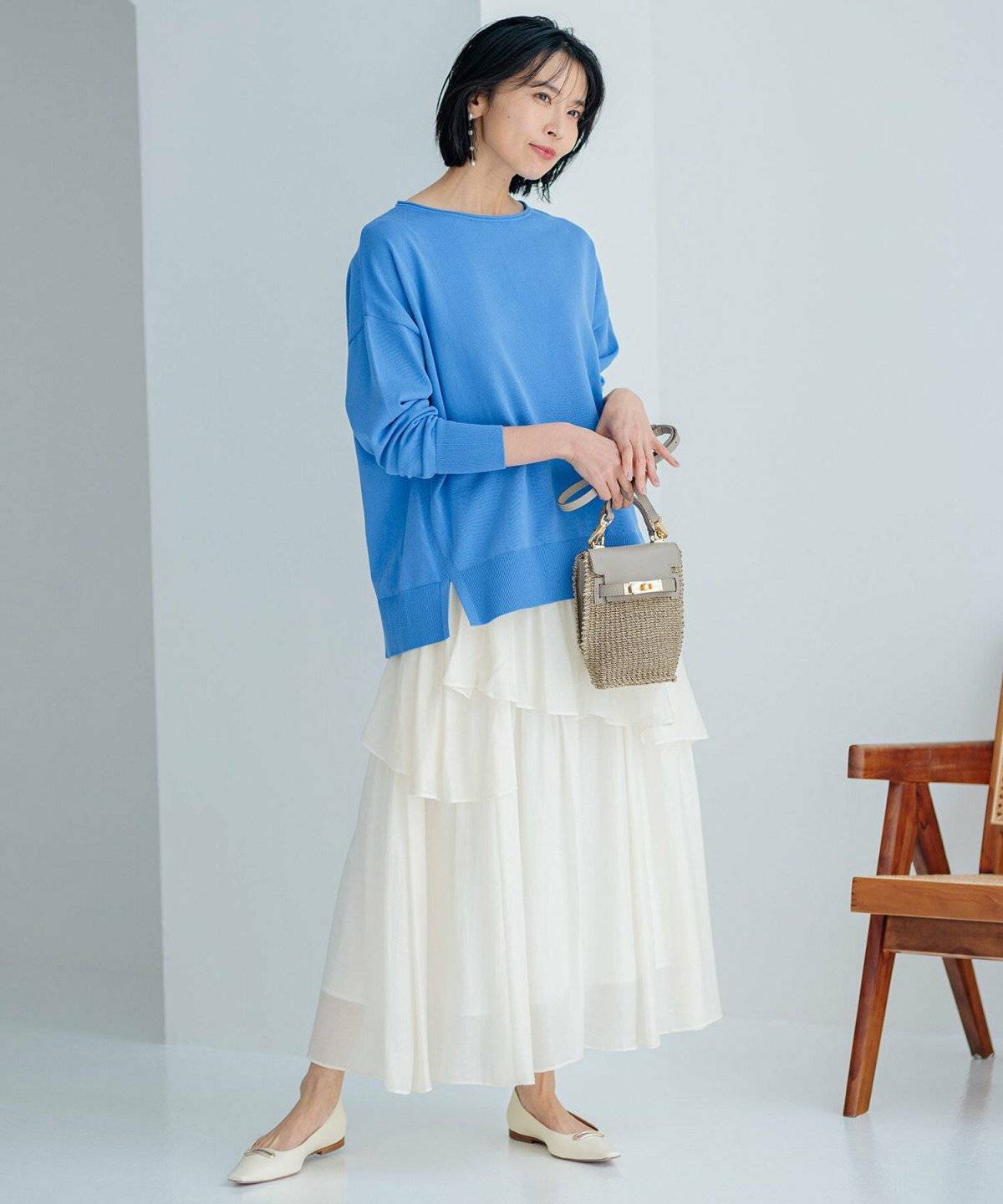 カラーニットに白スカートを合わせた女性
