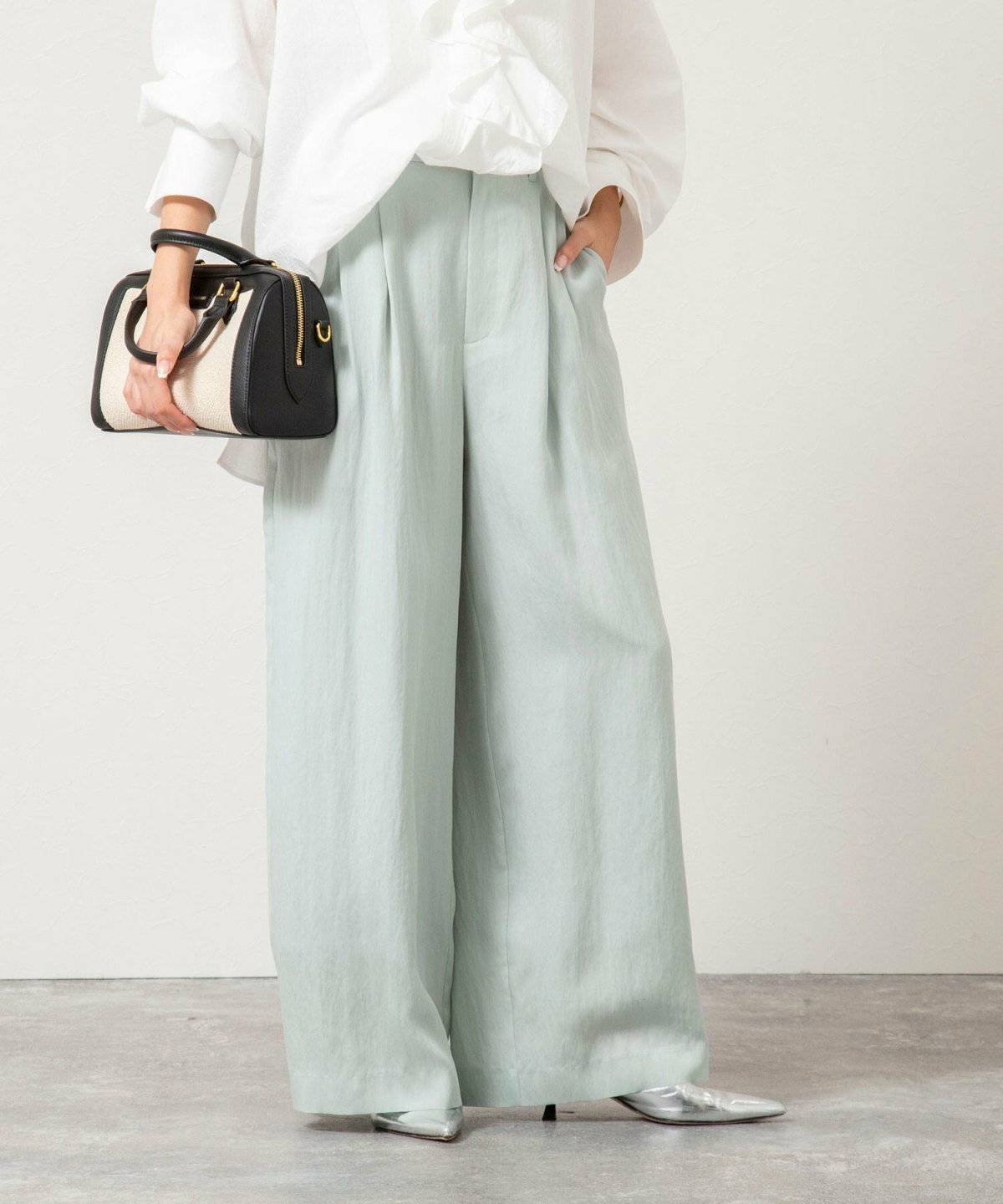 ミントグリーンワイドパンツ✕白シャツの女性