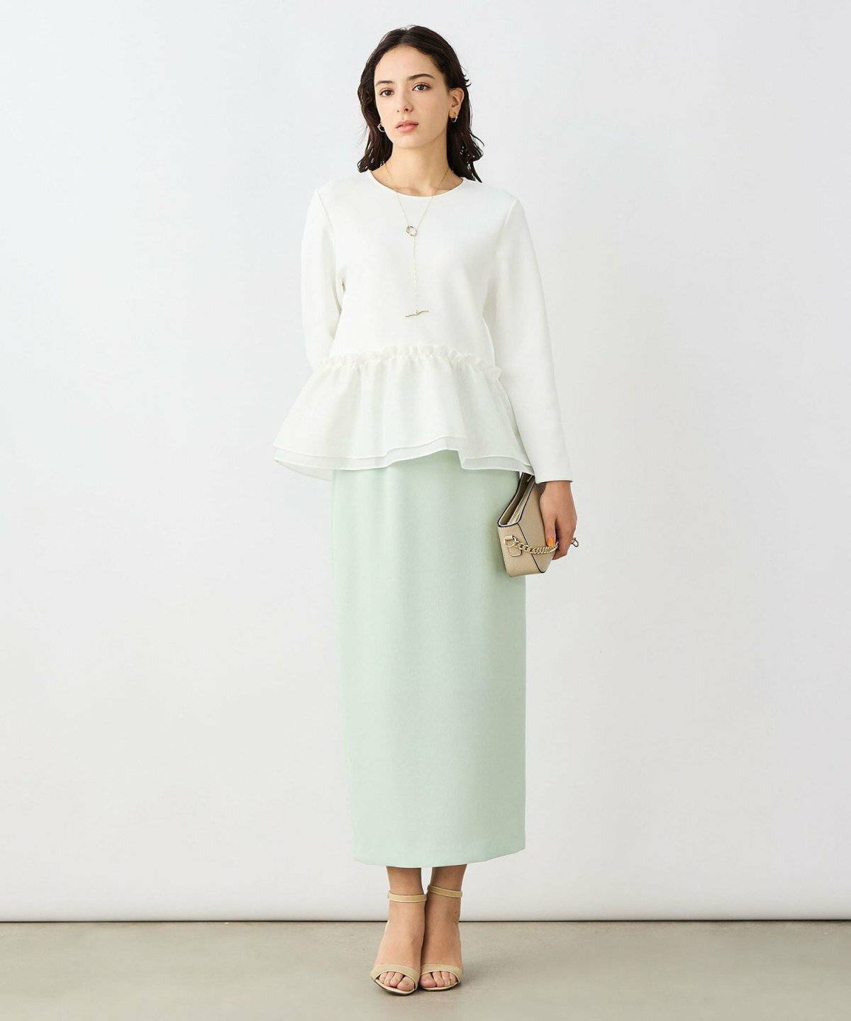 ミントグリーンシャツ✕白スカートの女性