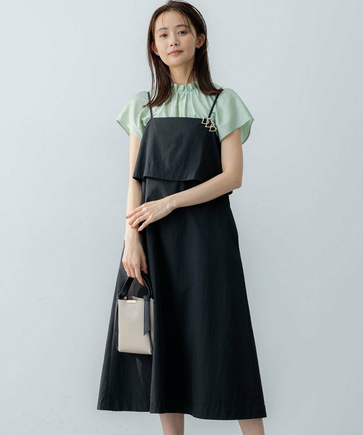 ミントグリーンブラウス✕黒ワンピの女性