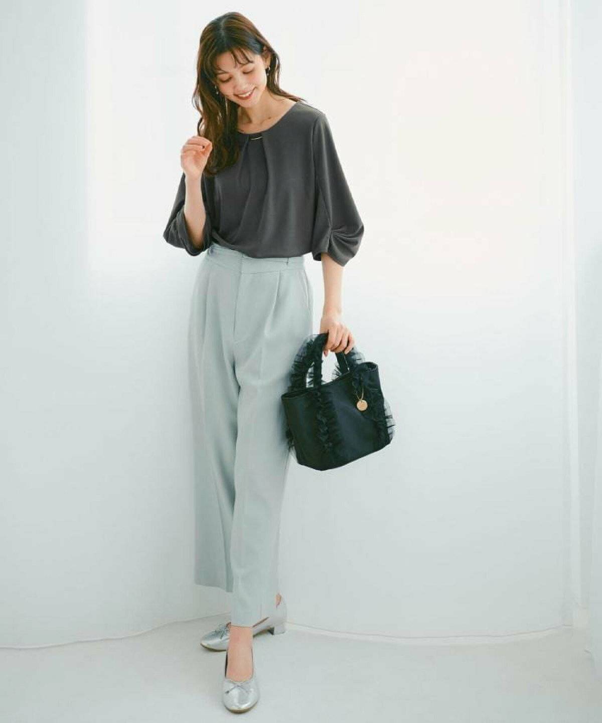 ミントグリーンストレートパンツ✕黒ニットプルオーバーの女性