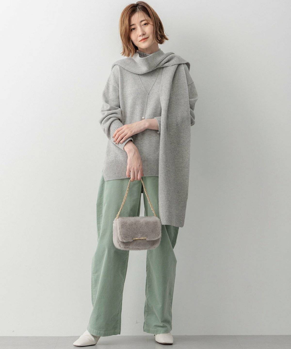 ミントグリーンワイドパンツ✕グレーのニットプルオーバーの女性