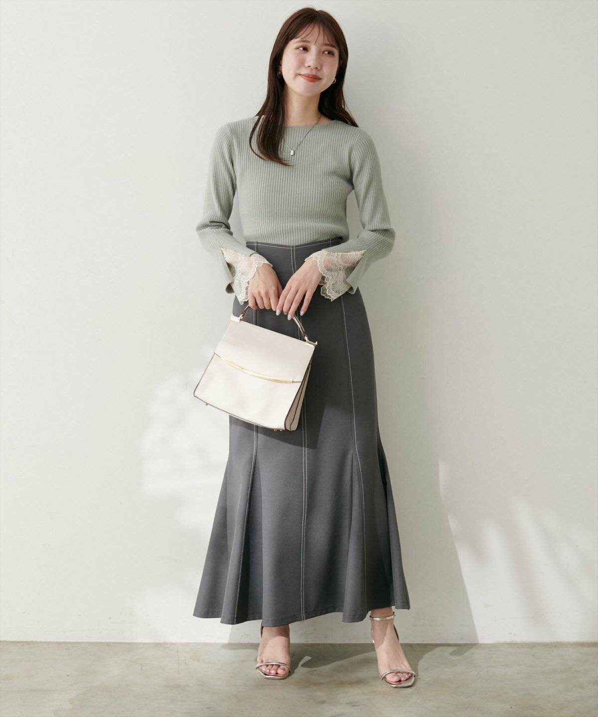 ミントグリーンハイネックニット✕グレーのスカートの女性