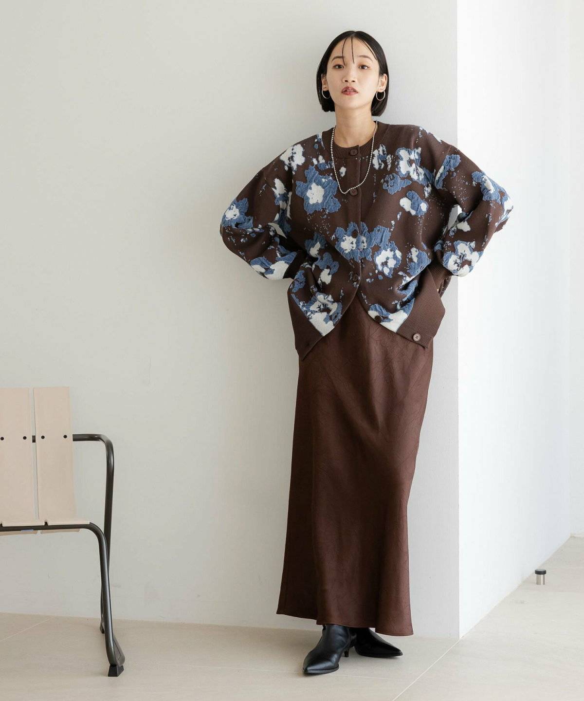 ブラウンコーデに鍵編みカーディガンを羽織った女性