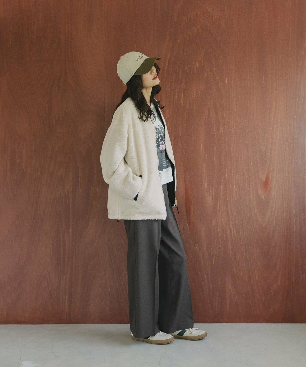 ベージュのスウェットにグレーのパンツを合わせた女性
