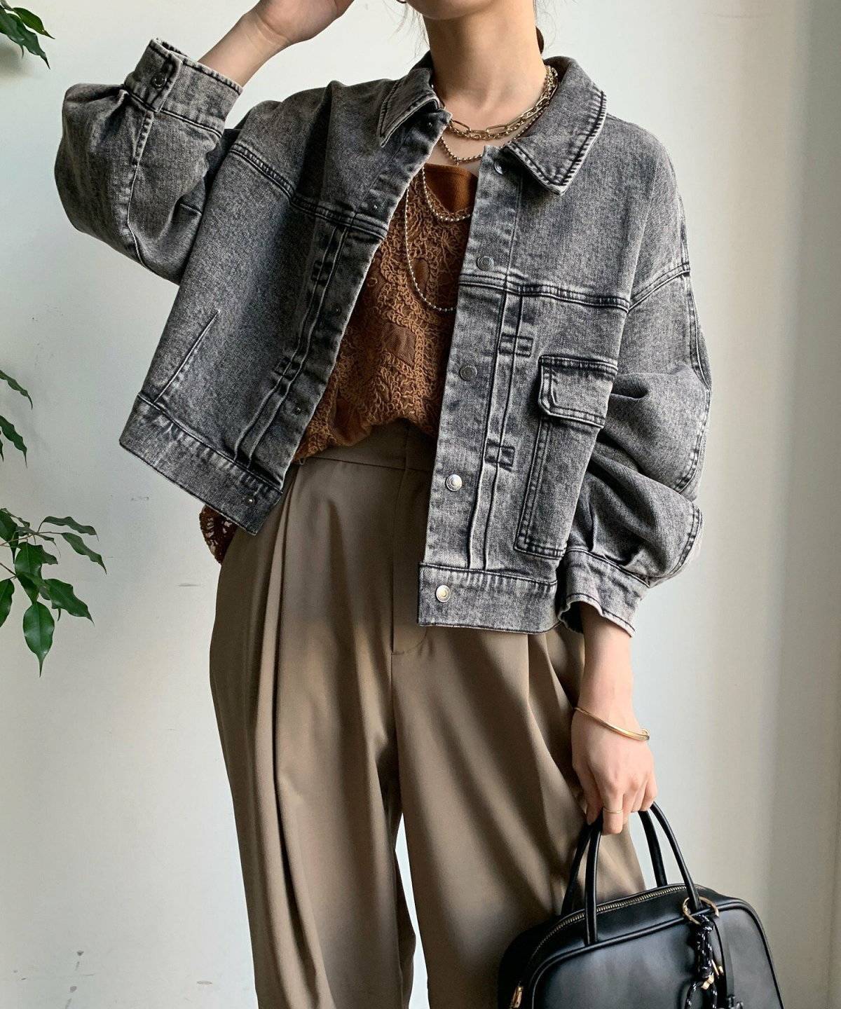 黒アウターにブラウンパンツを合わせた女性