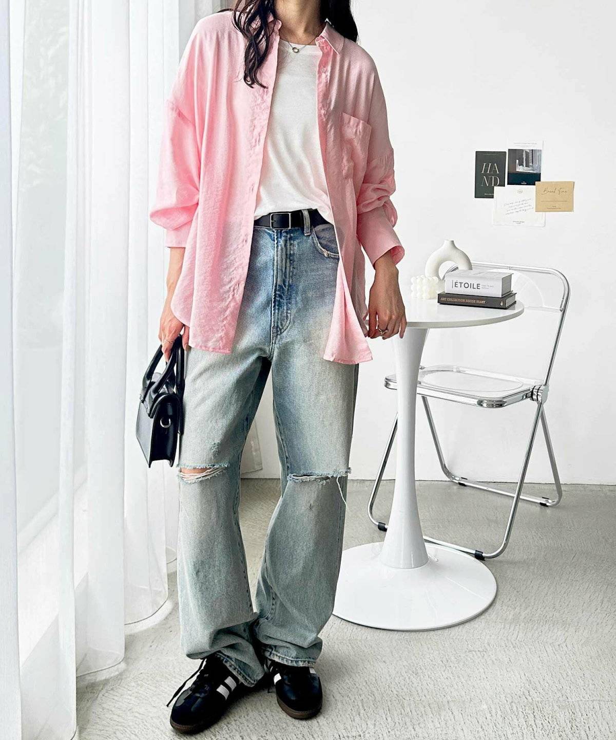 ピンクのシャツにデニムを合わせた女性