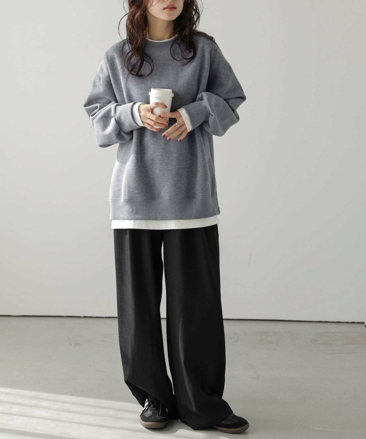グレーのスウェットに黒パンツを合わせた女性