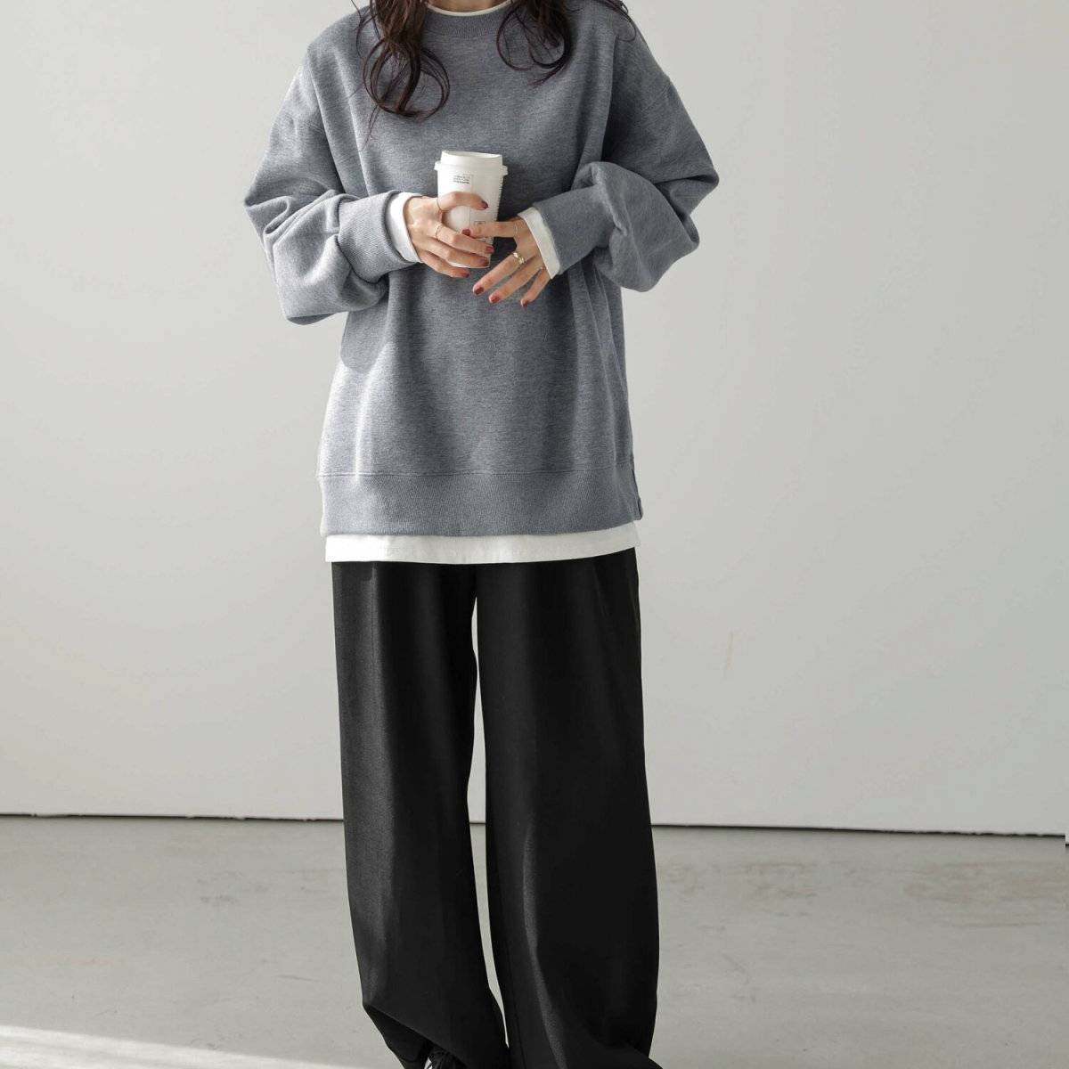 グレーのスウェットに黒パンツを合わせた女性