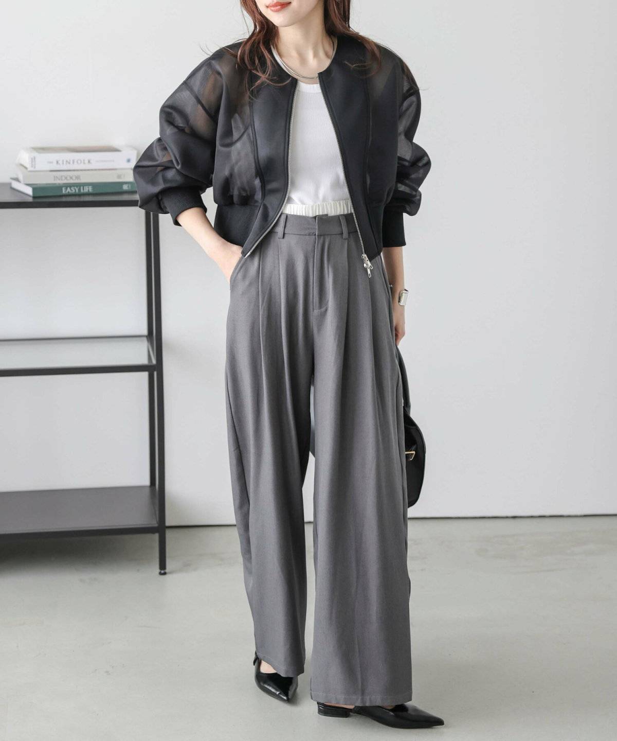 キャミソールにブルゾンを羽織ってパンツを合わせた女性