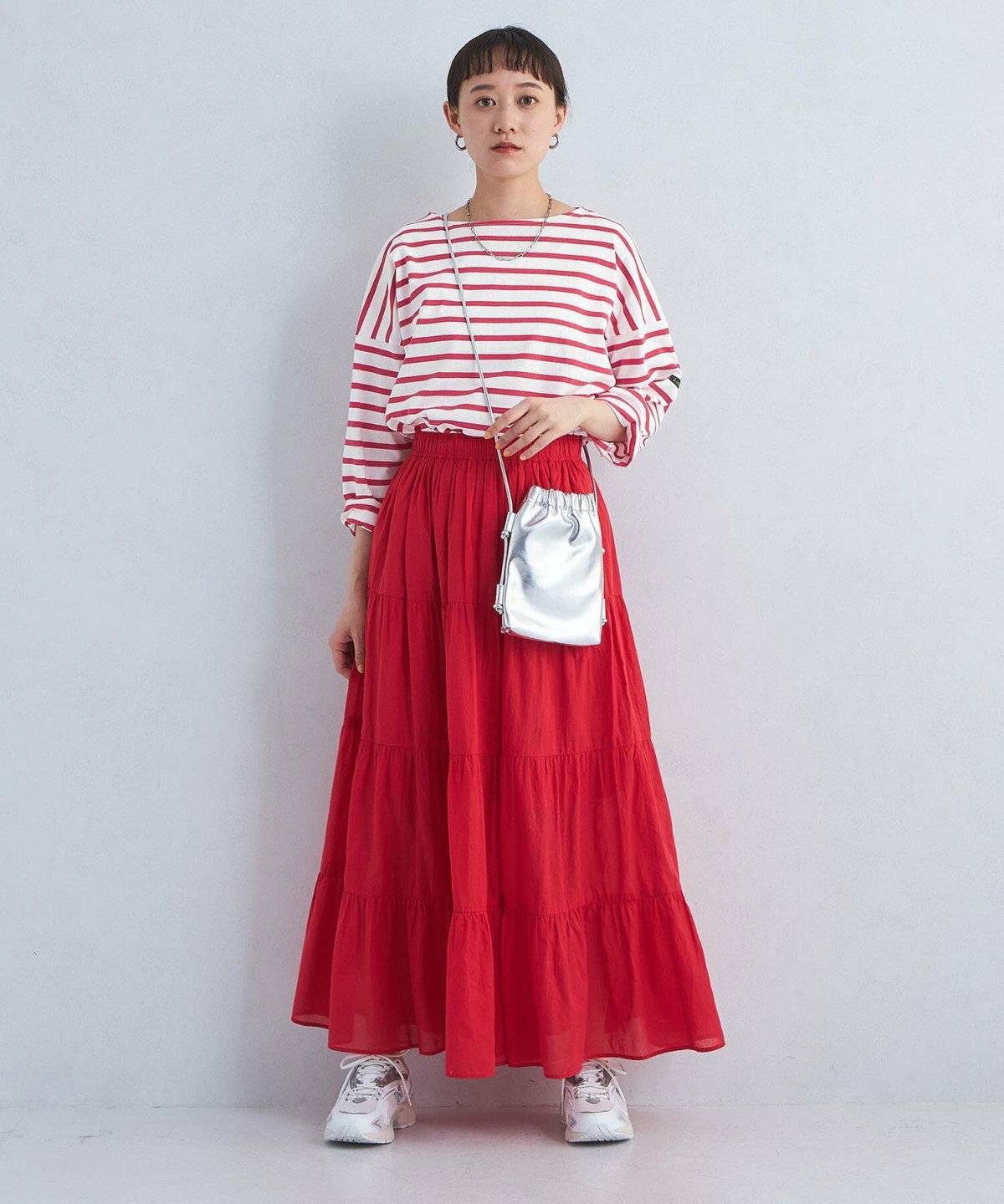 ボーダー柄のトップスにカラースカートを合わせた女性