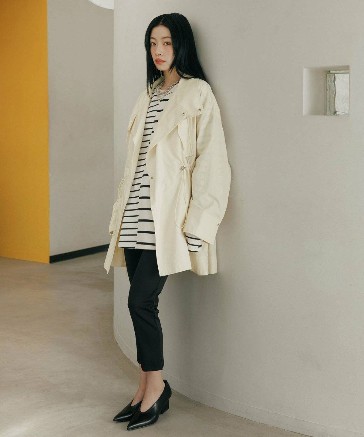 ボーダー柄トップスにデニムを合わせてコートを羽織った女性