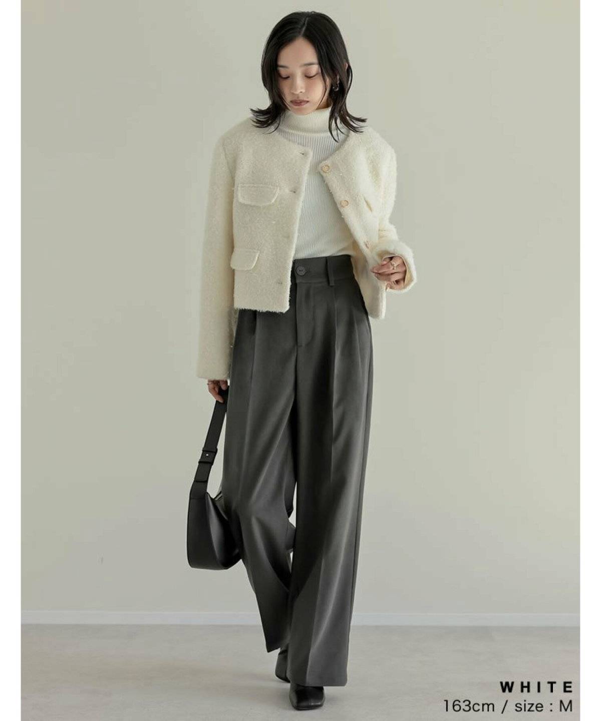 ジャケットにグレーのパンツを合わせた女性