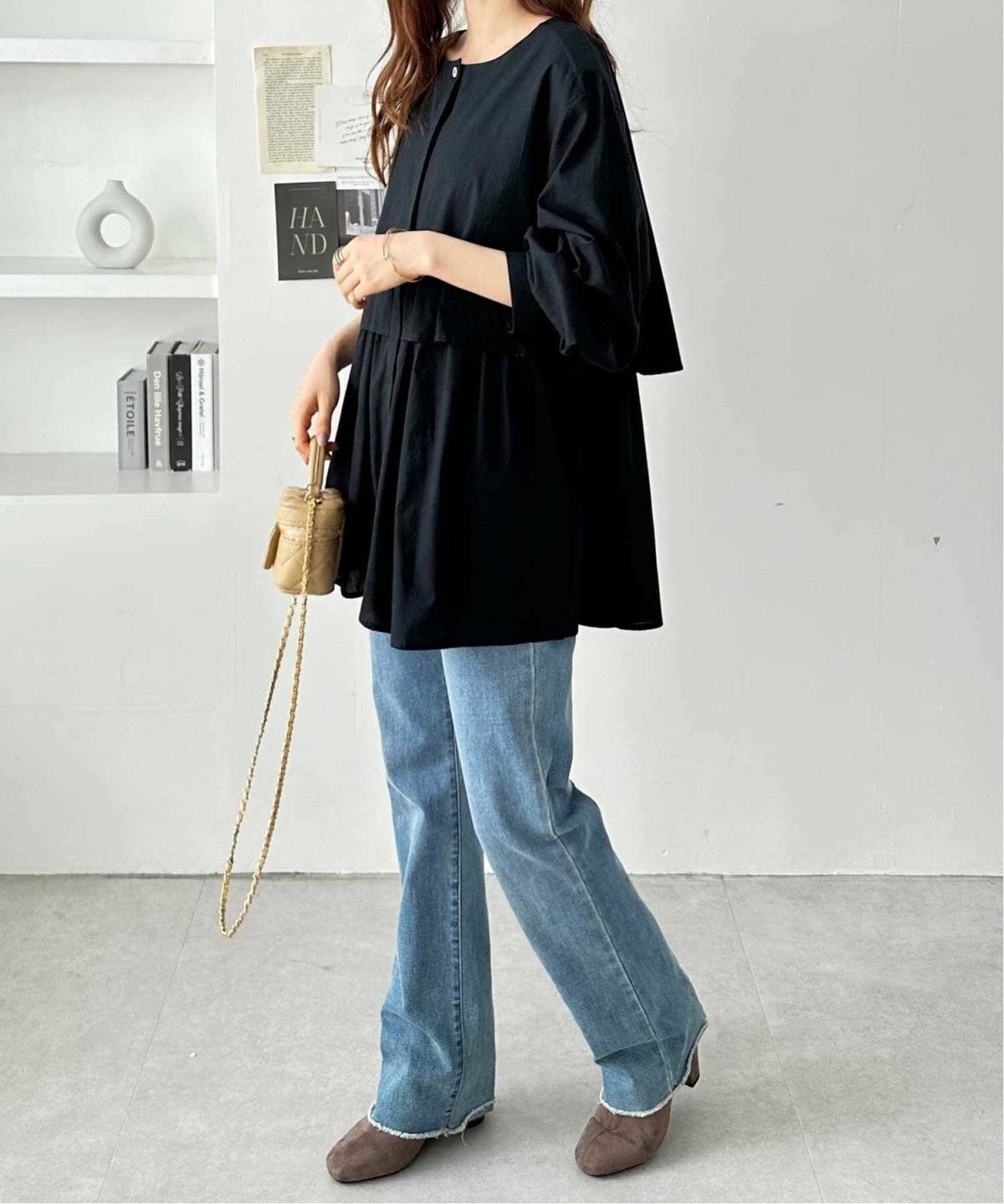 黒ブラウスにデニムを合わせた女性