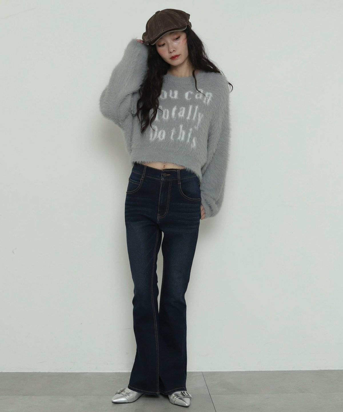 ピンクのニットにデニムを合わせた女性