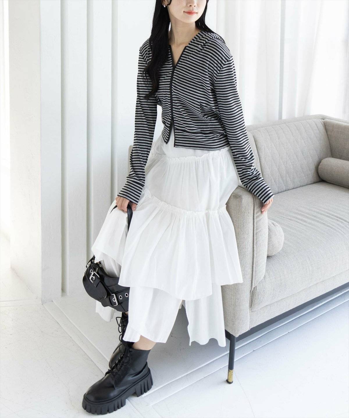 ボーダー柄カーディガンにスカートを合わせた女性