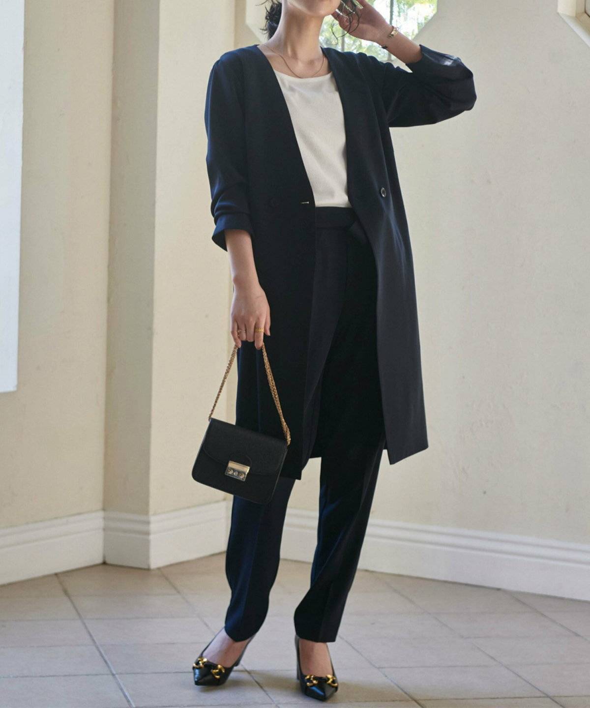 ブラックコーデにグレーのジャケットを羽織った女性