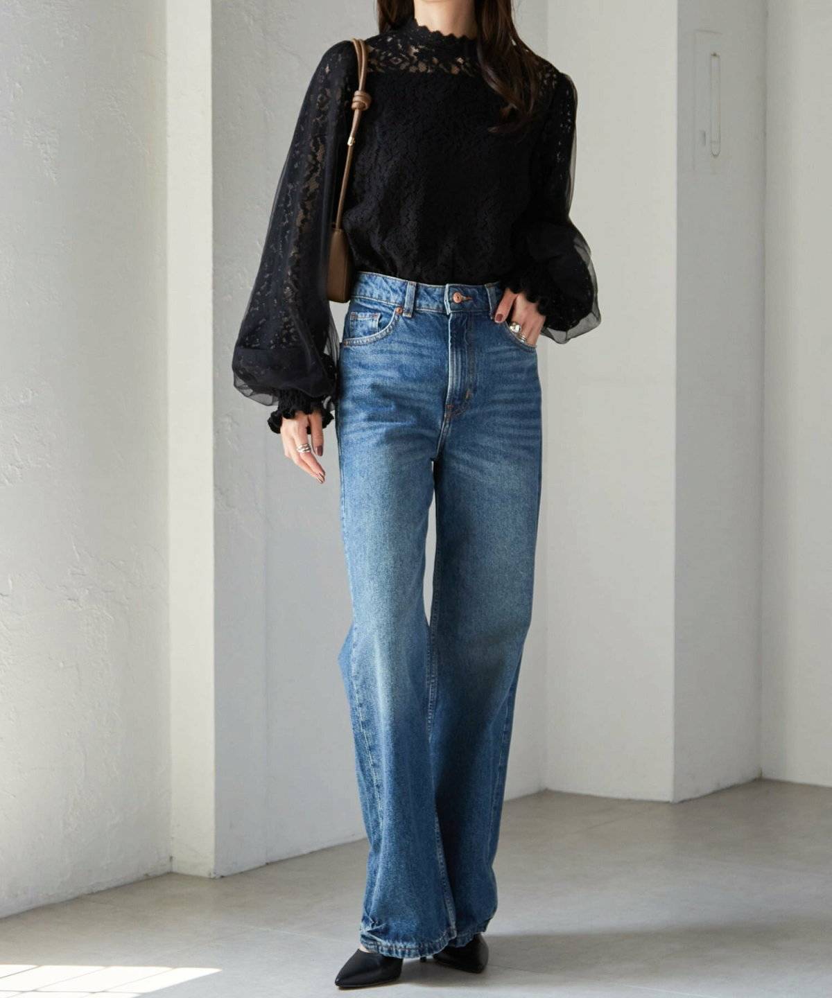 黒ブラウスにデニムを合わせた女性