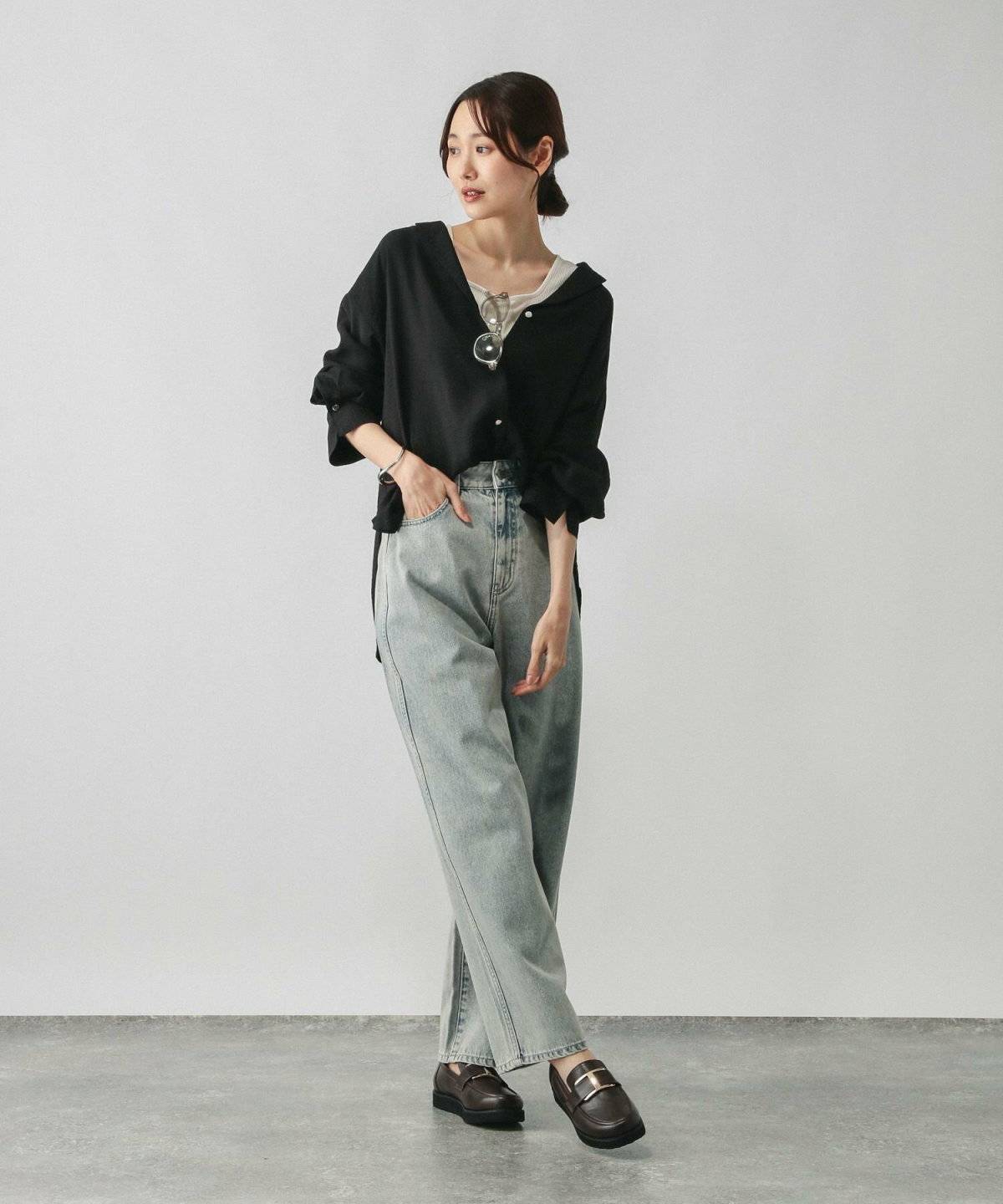 黒シャツにデニムを合わせた女性
