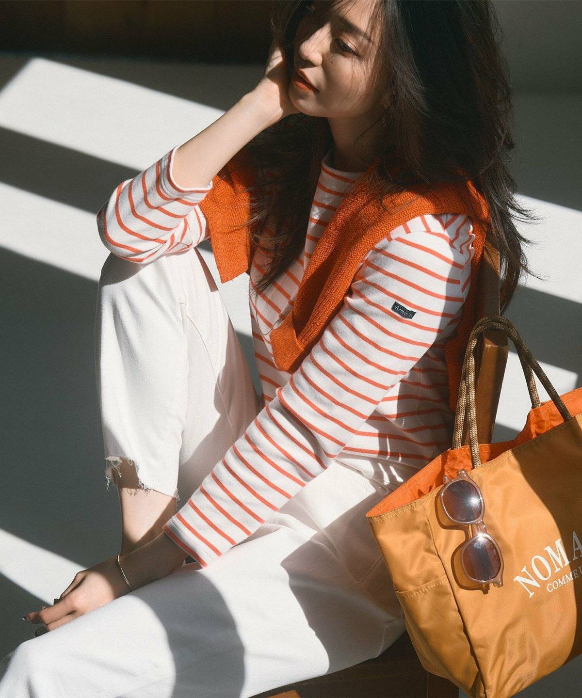 ボーダー柄トップスに白デニムを合わせた女性