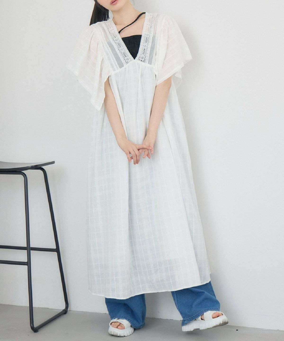 Tシャツとデニムに黒ワンピースを合わせた女性